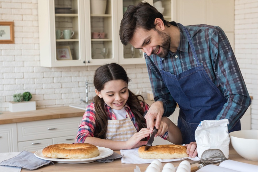Conflictos en casa durante la cuarentena, Padre e Hija se divierten cocinando y cortando un pan